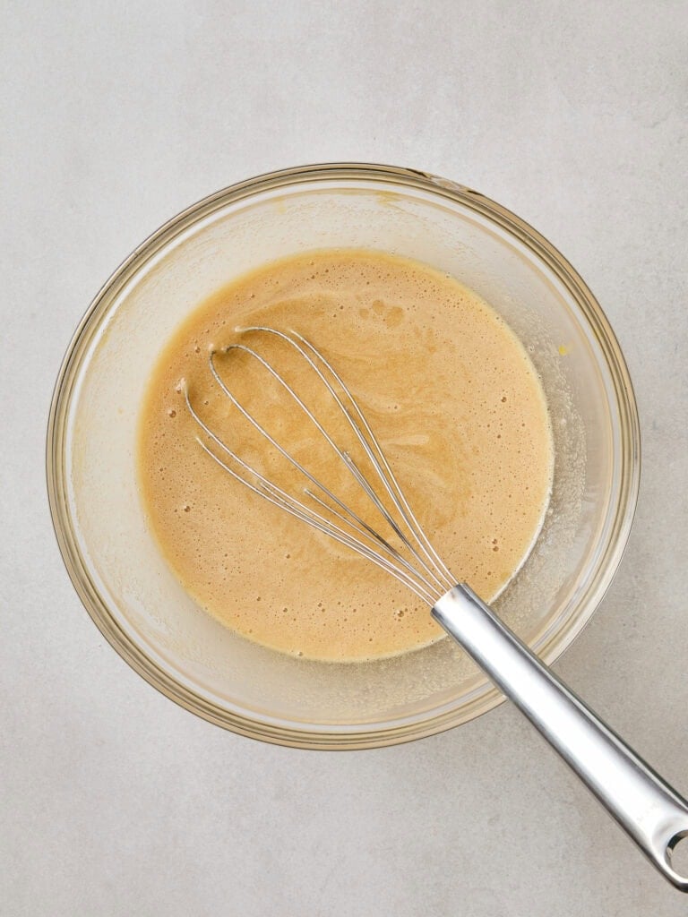 Wet ingredients for pumpkin spice donuts mixed together.