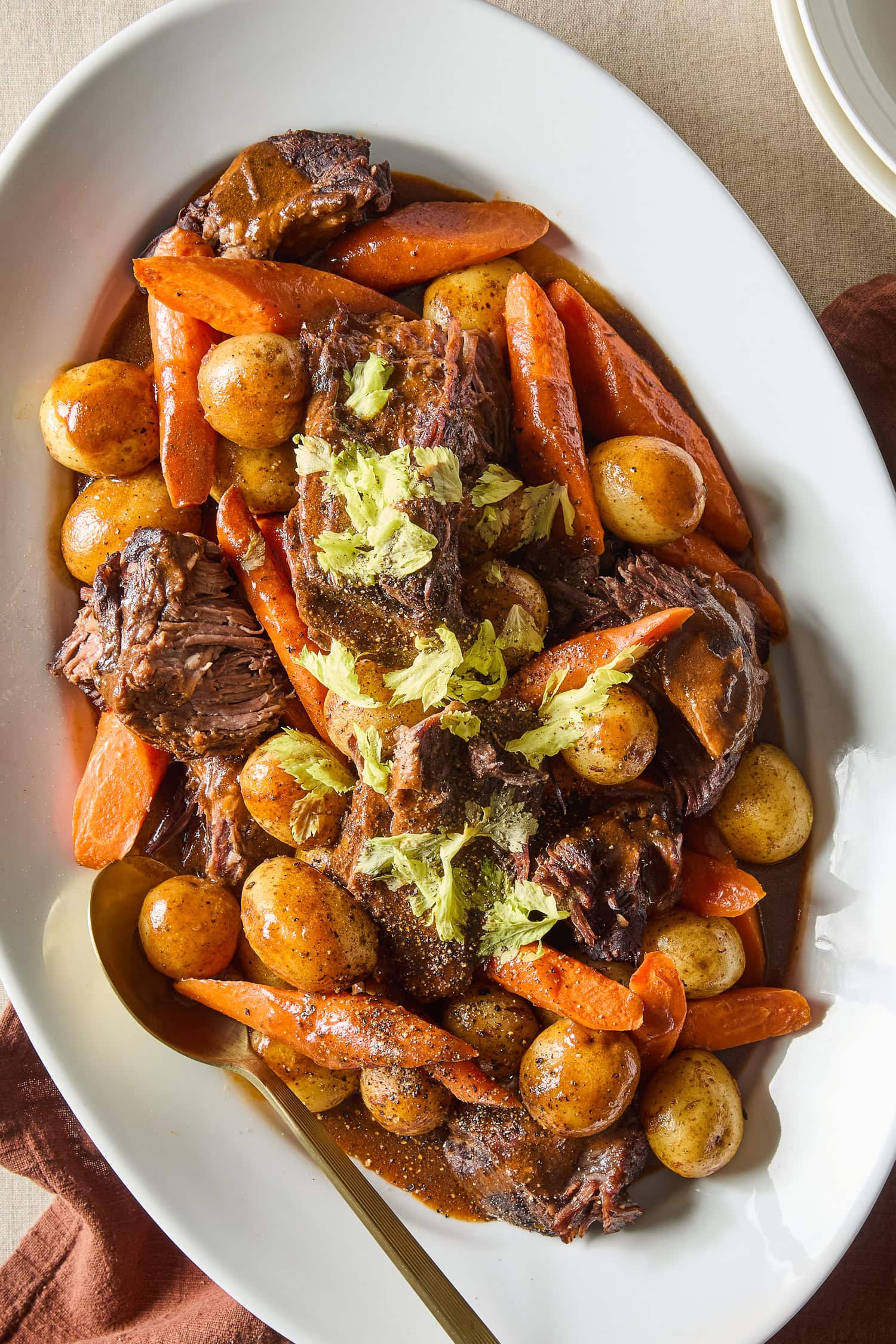 A classic pot roast garnished with parsley rests on a platter.