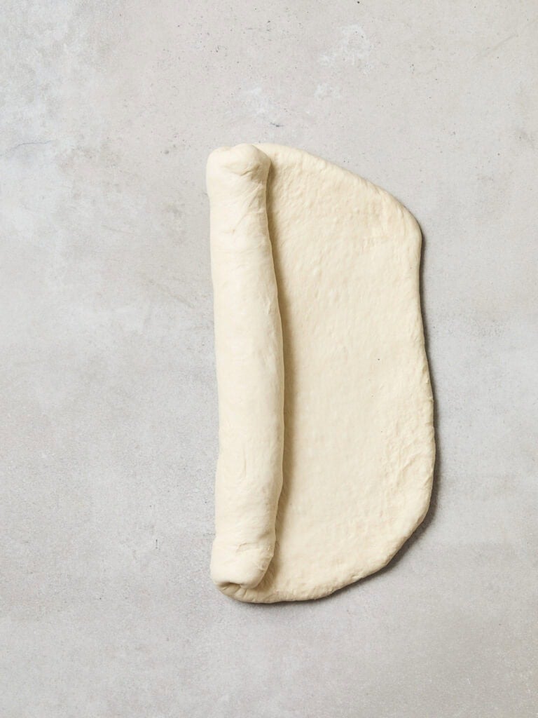Bread dough being rolled into a form.