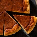Basque cheesecake with dark top with slices cut out.