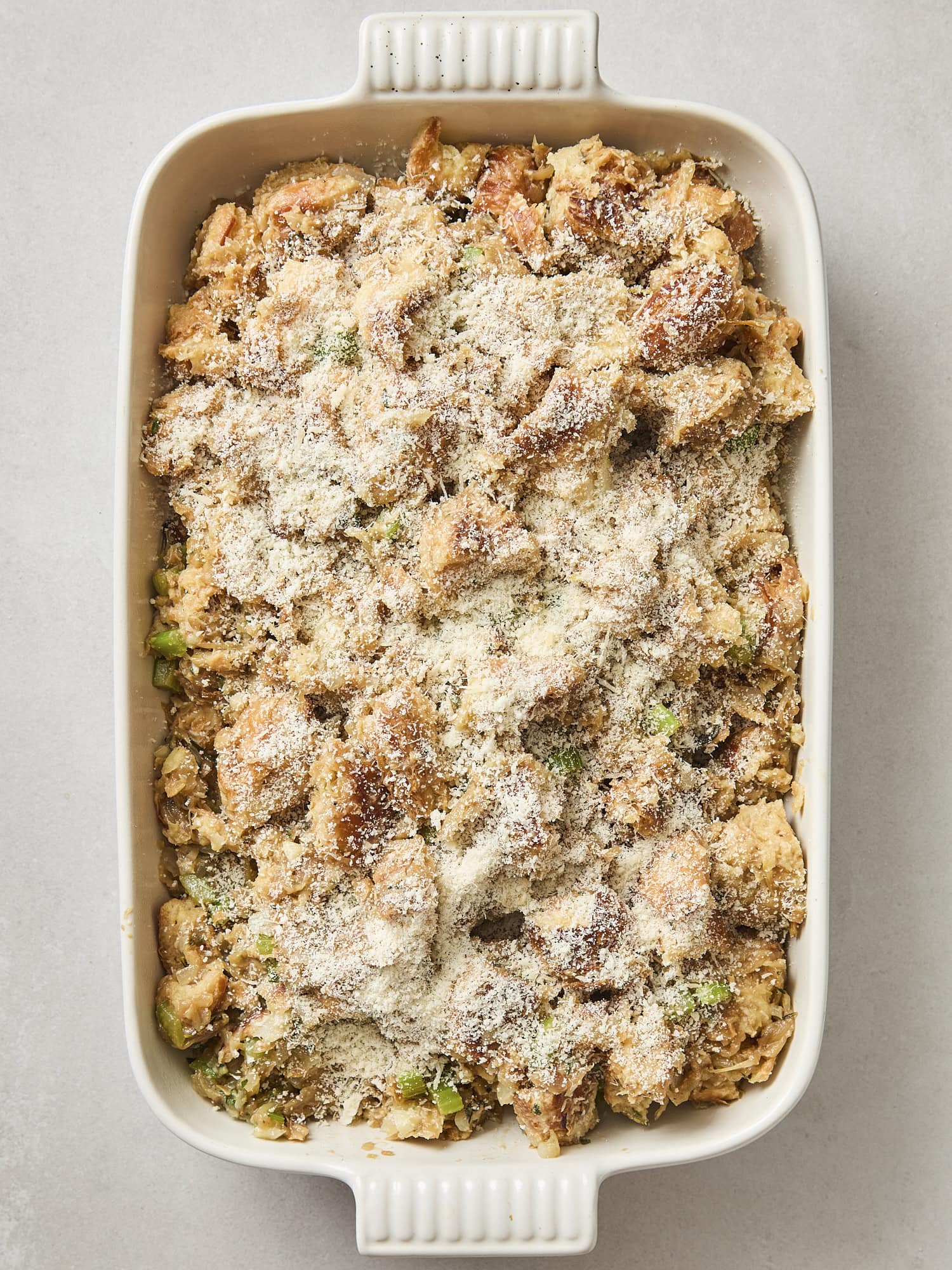 Unbaked croissant stuffing with fresh Parmesan cheese on top.