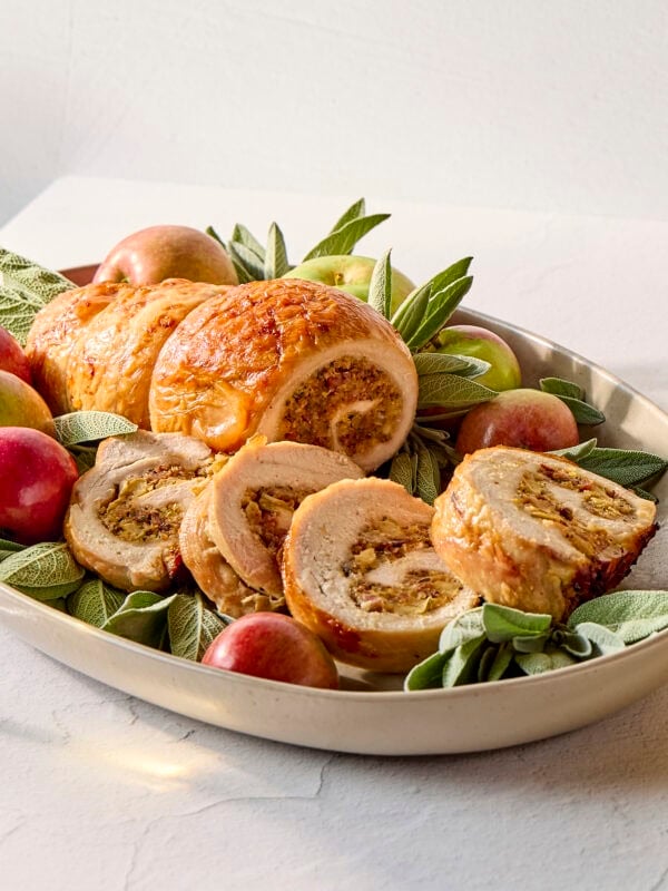 Platter with rolled up turkey stuffed with apple and sage filling.