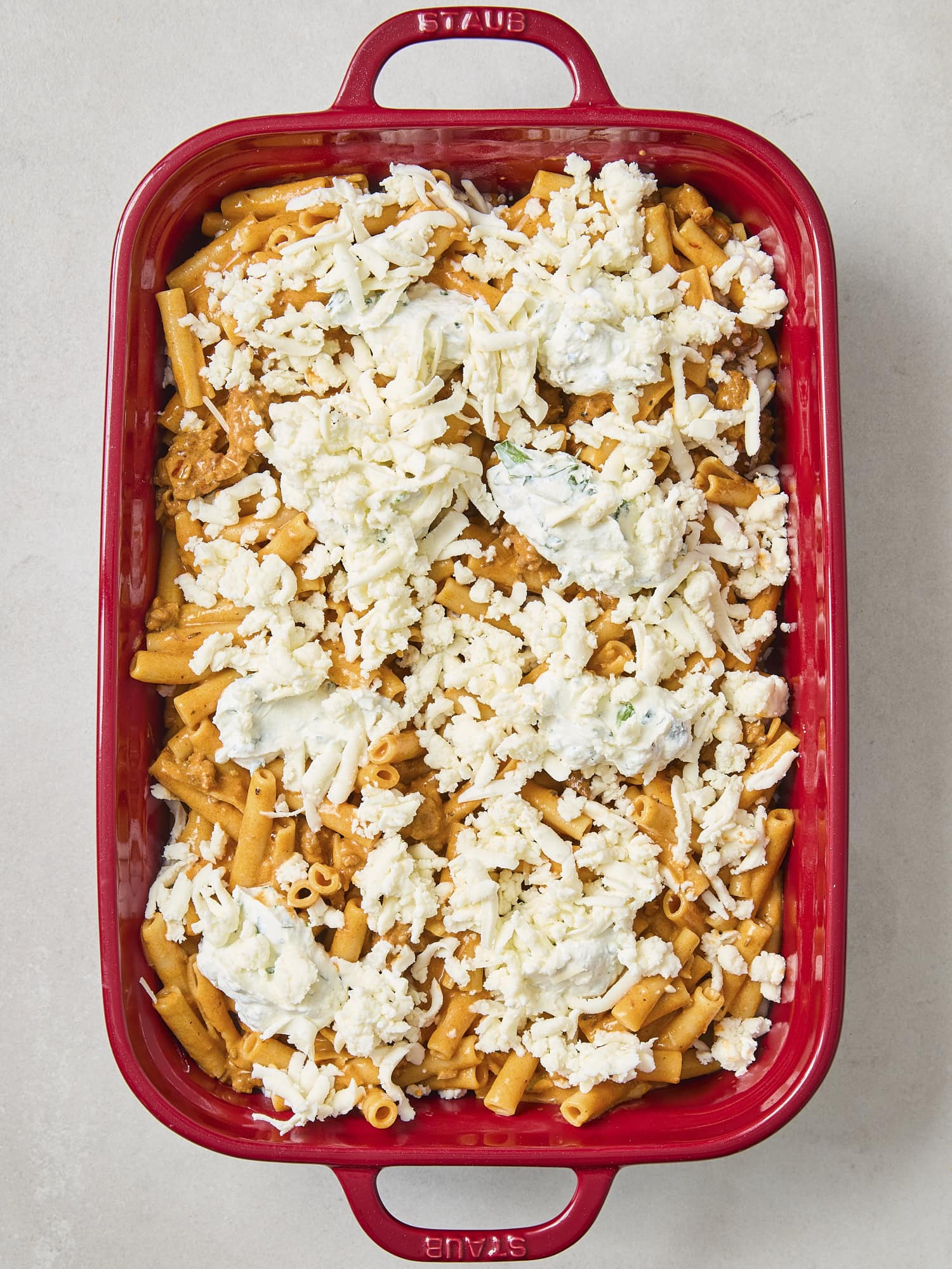 Shredded mozzarella cheese on top of pasta.