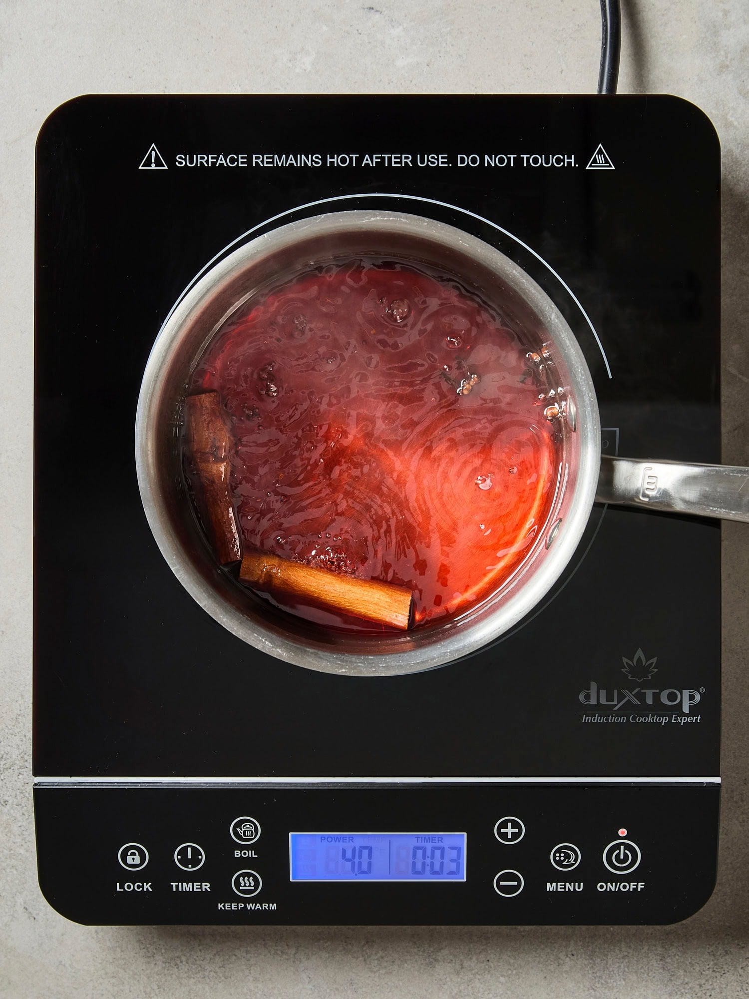 Cranberry simple syrup mixture cooking on the stove in a pan.