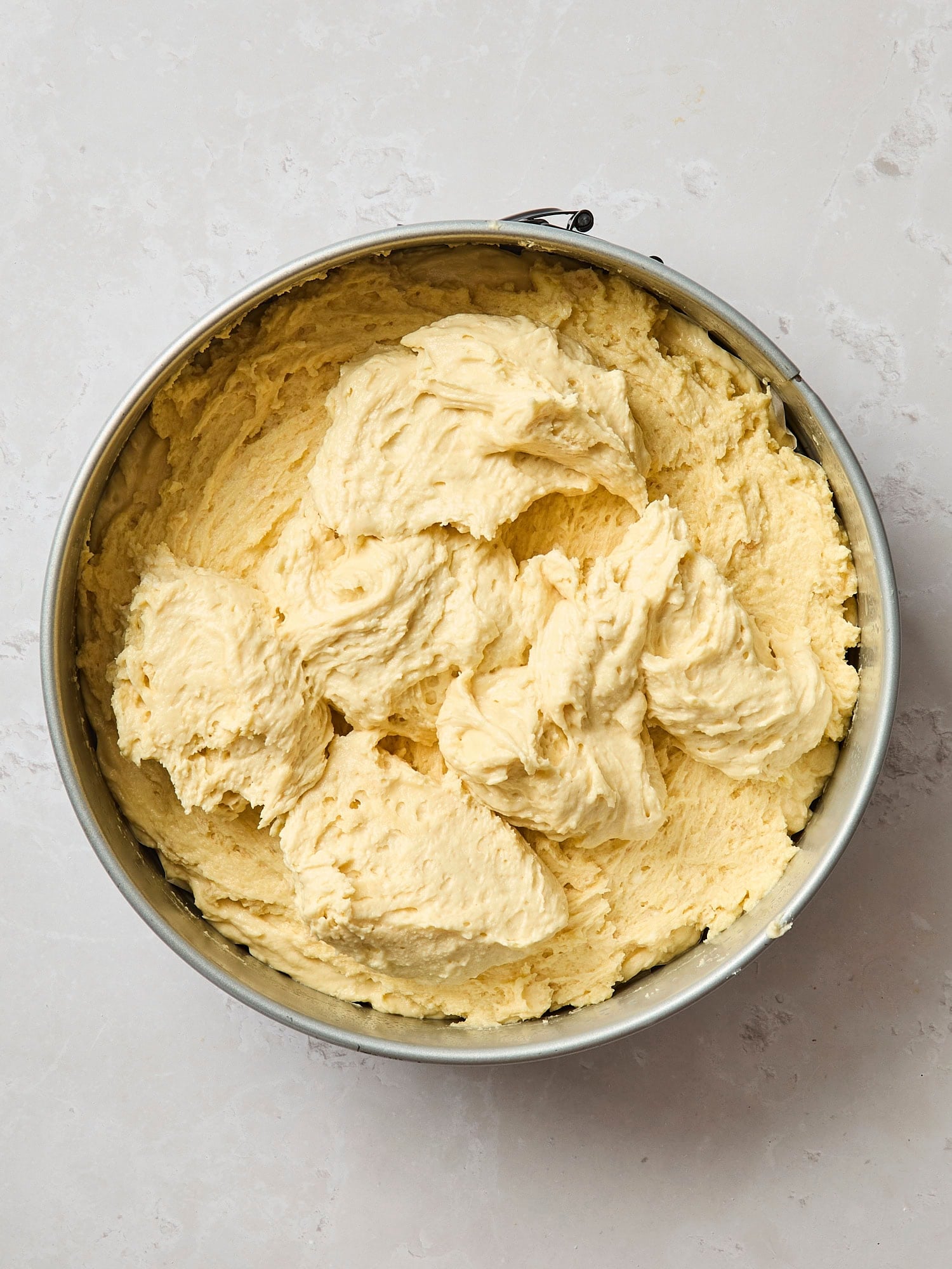 Dollops of batter on top of more batter to create a layered coffee cake.