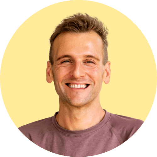Kaleb Wyse standing in front of yellow background.