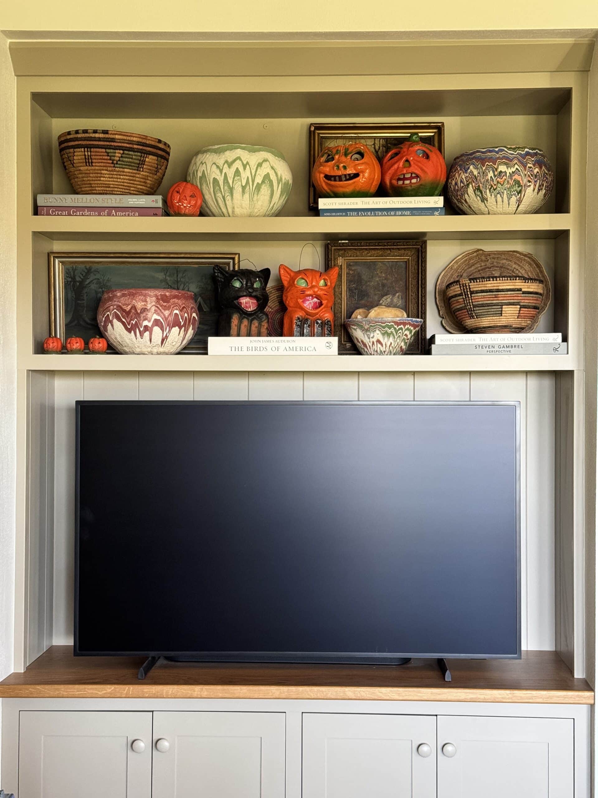 Shelves with a TV with small Halloween decor.