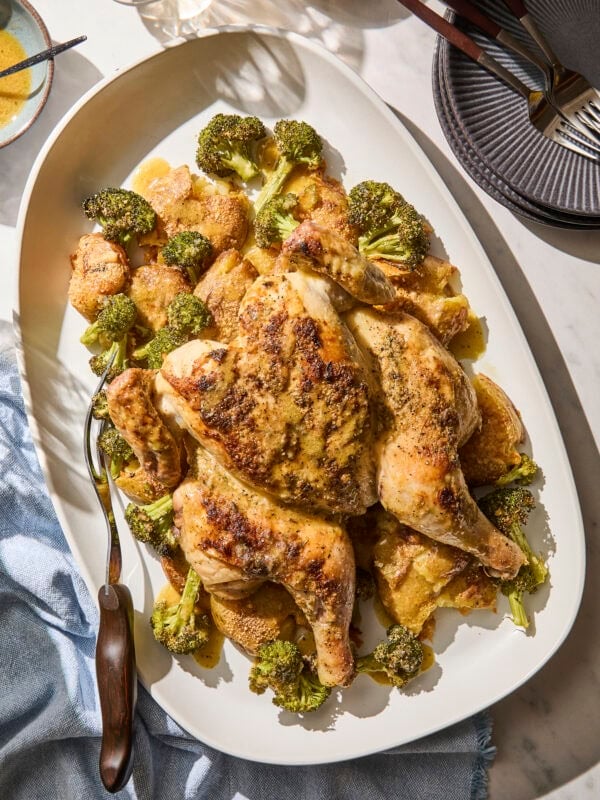 Platter with sheet pan chicken and potatoes and broccoli.