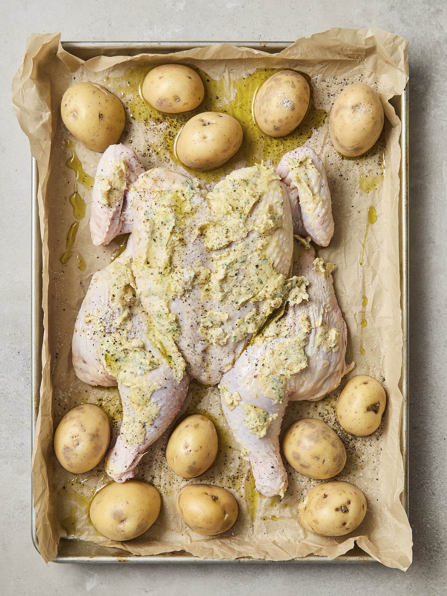 Chicken and potatoes before roasting in oven.