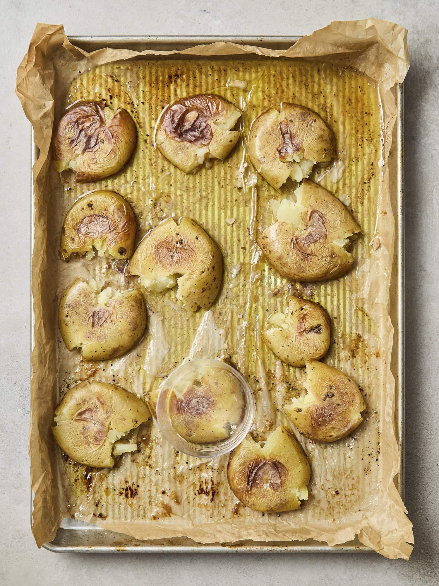 Smashed roasted potatoes with a glass.
