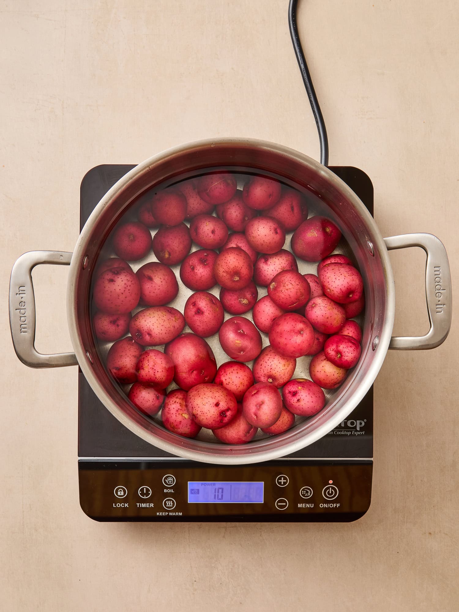 Potatoes in a pot of water beginning to cook.