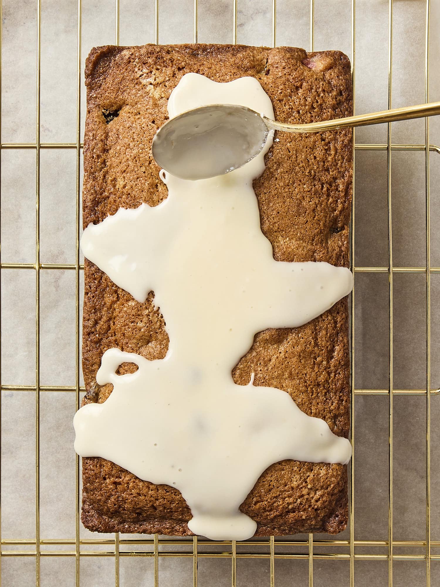 Glaze being poured on cooled pound cake.