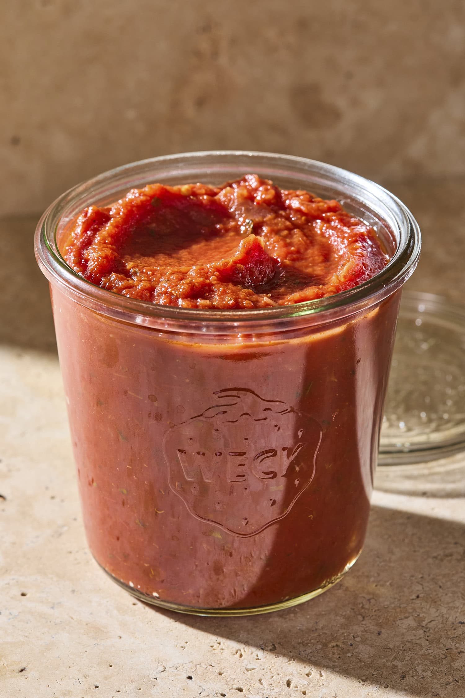 Glass jar filled with red homemade marinara sauce.