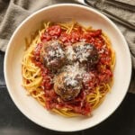 A serving of spaghetti with meatballs on a small plate.