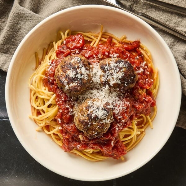A serving of spaghetti with meatballs on a small plate.