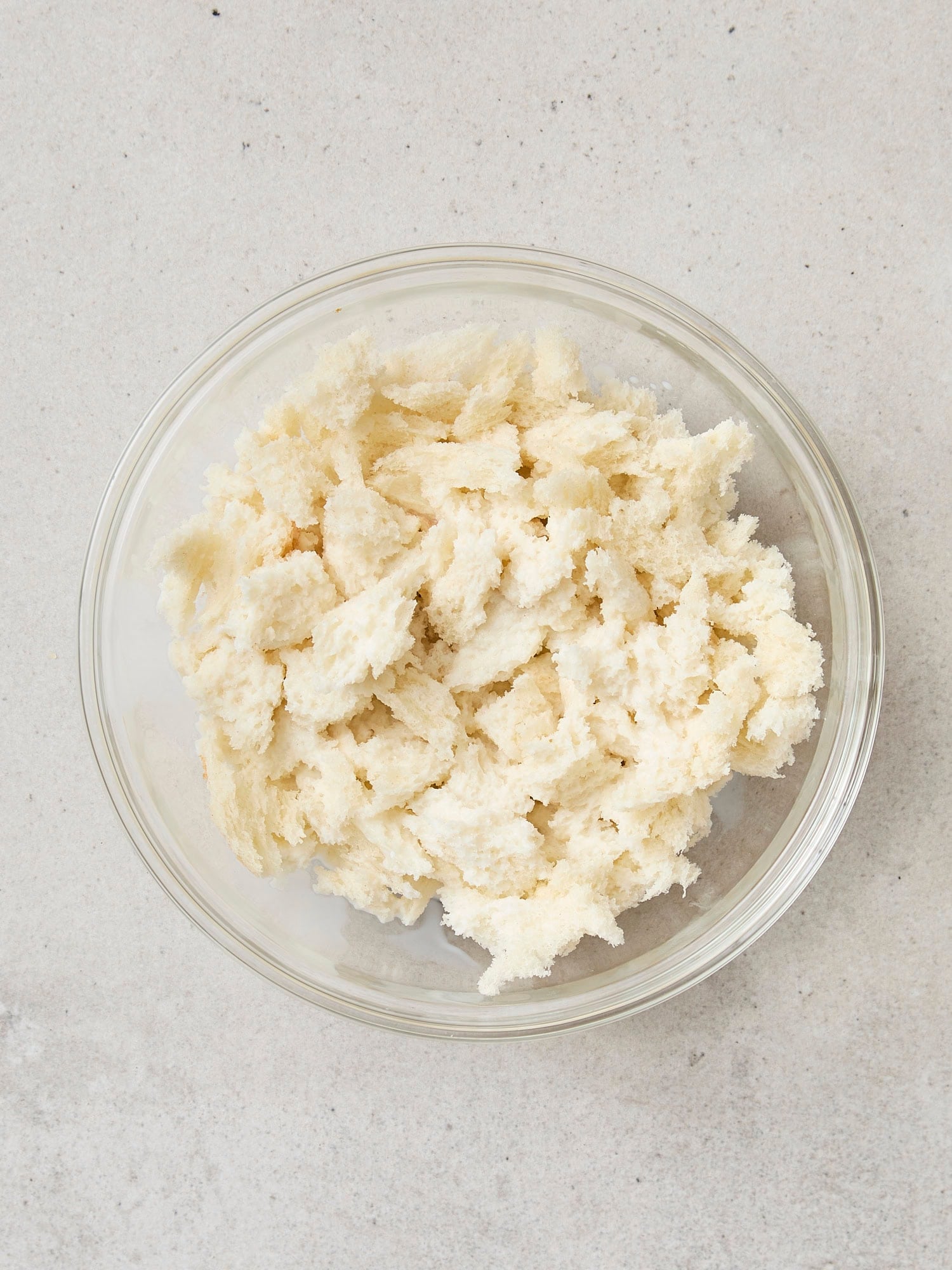 Pieces of ripped bread in a small glass bowl.