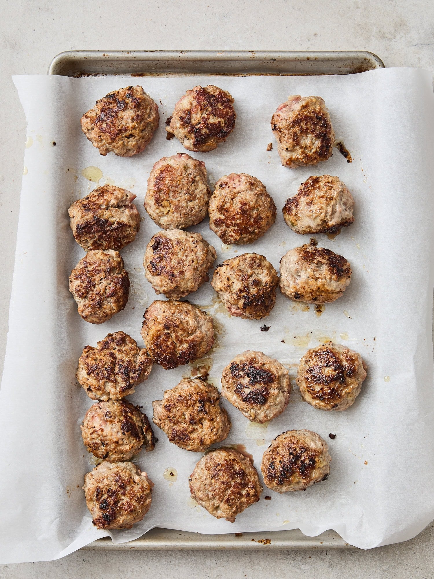 Meatballs on a baking tray after coming out of the oven.
