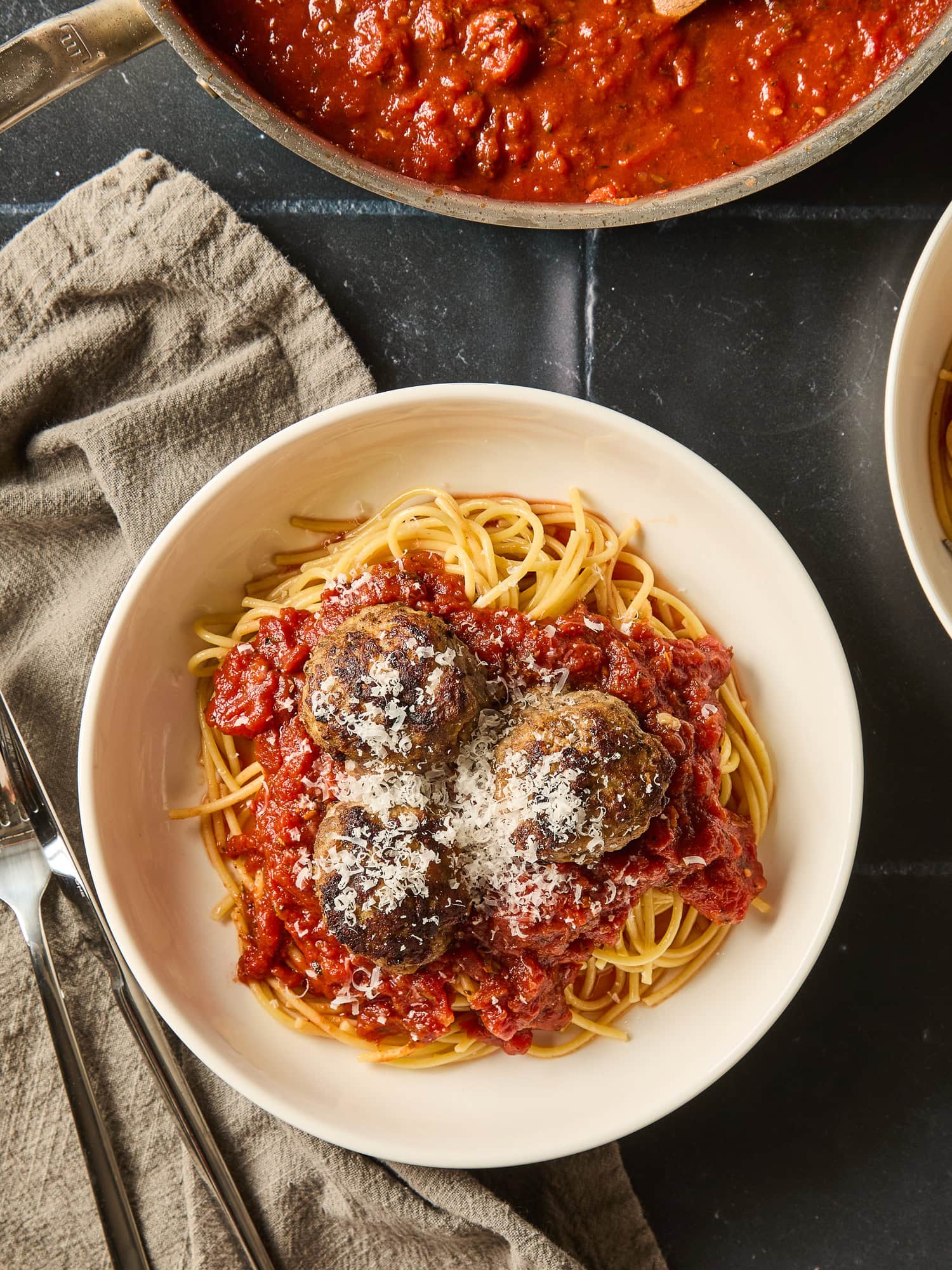 A small plate with spaghetti, red sauce, and meatballs.