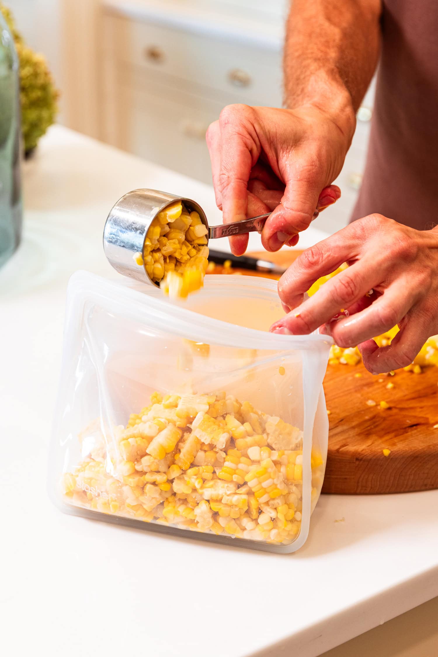 Placing sweet corn into freezer-safe bags.