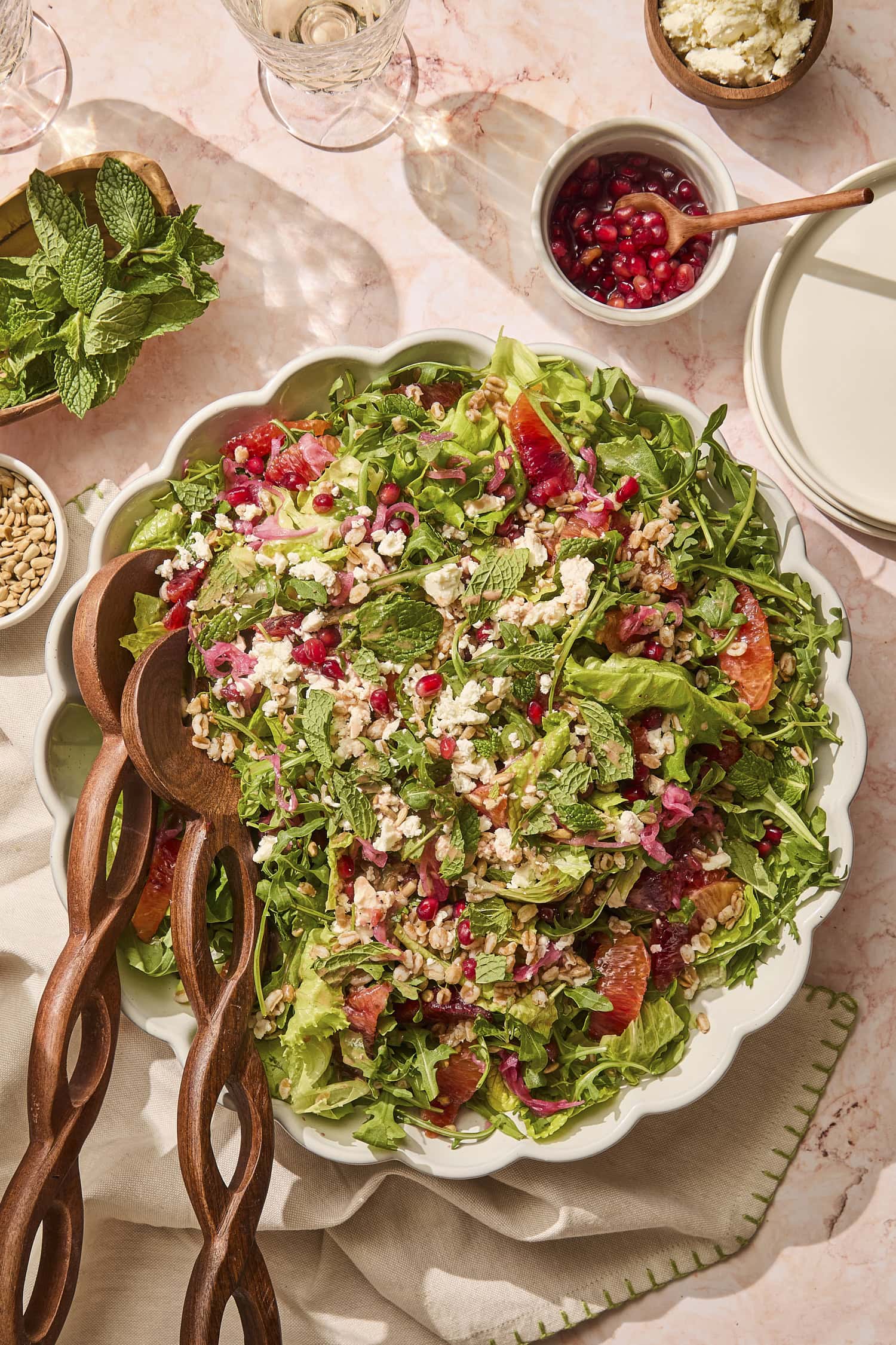 Large platter filled with farro salad with blood orange segments, pomegranates, feta, and more.