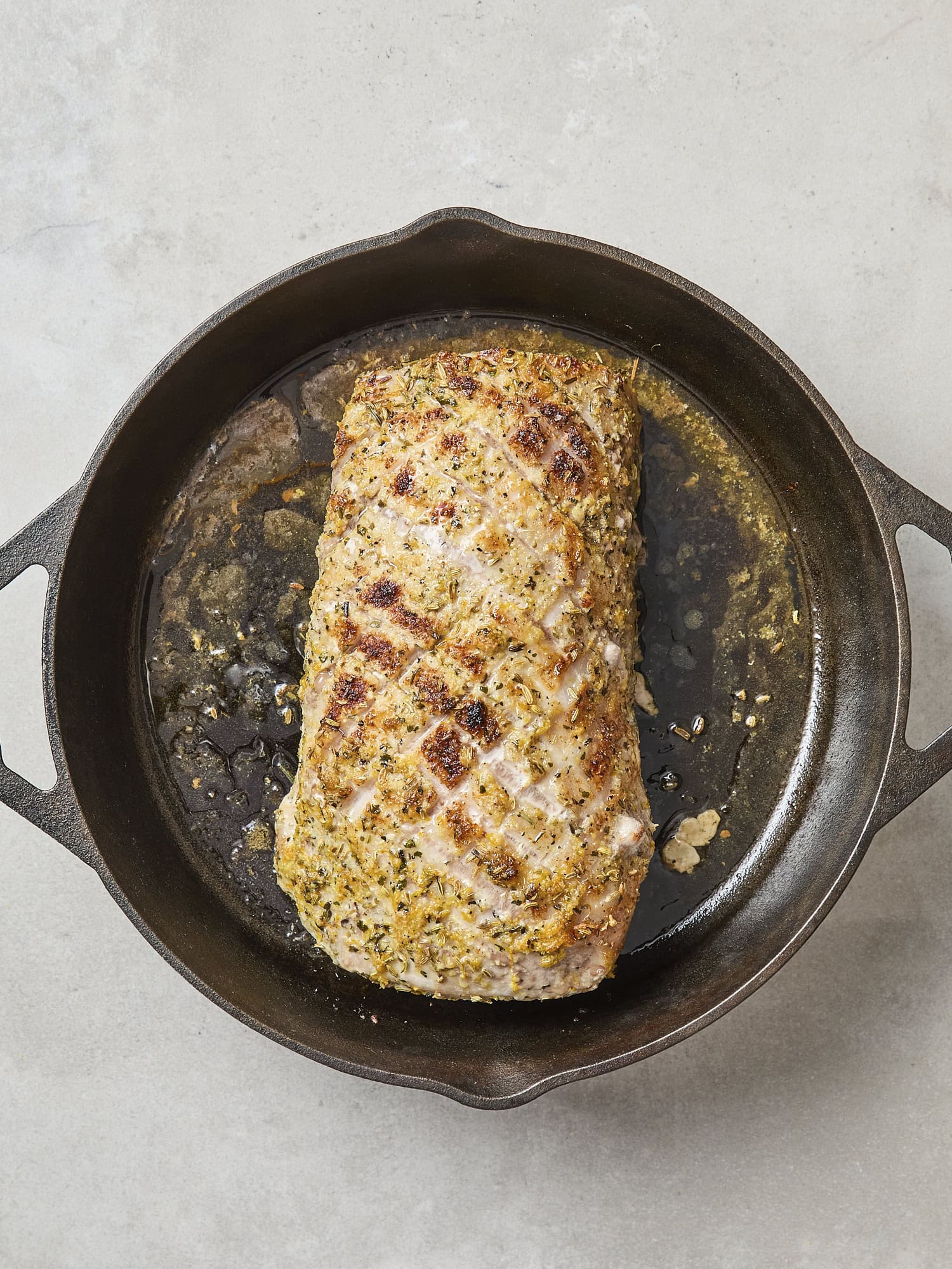 Skillet with browned citrus glazed pork roast.