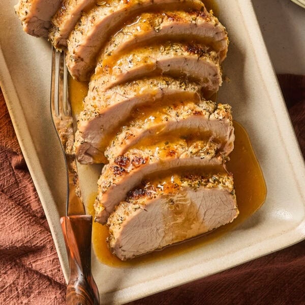 Slices of pork roast on a platter with glaze on top.