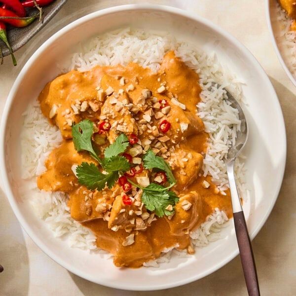 Bowl with butter chicken spooned on top of rice.