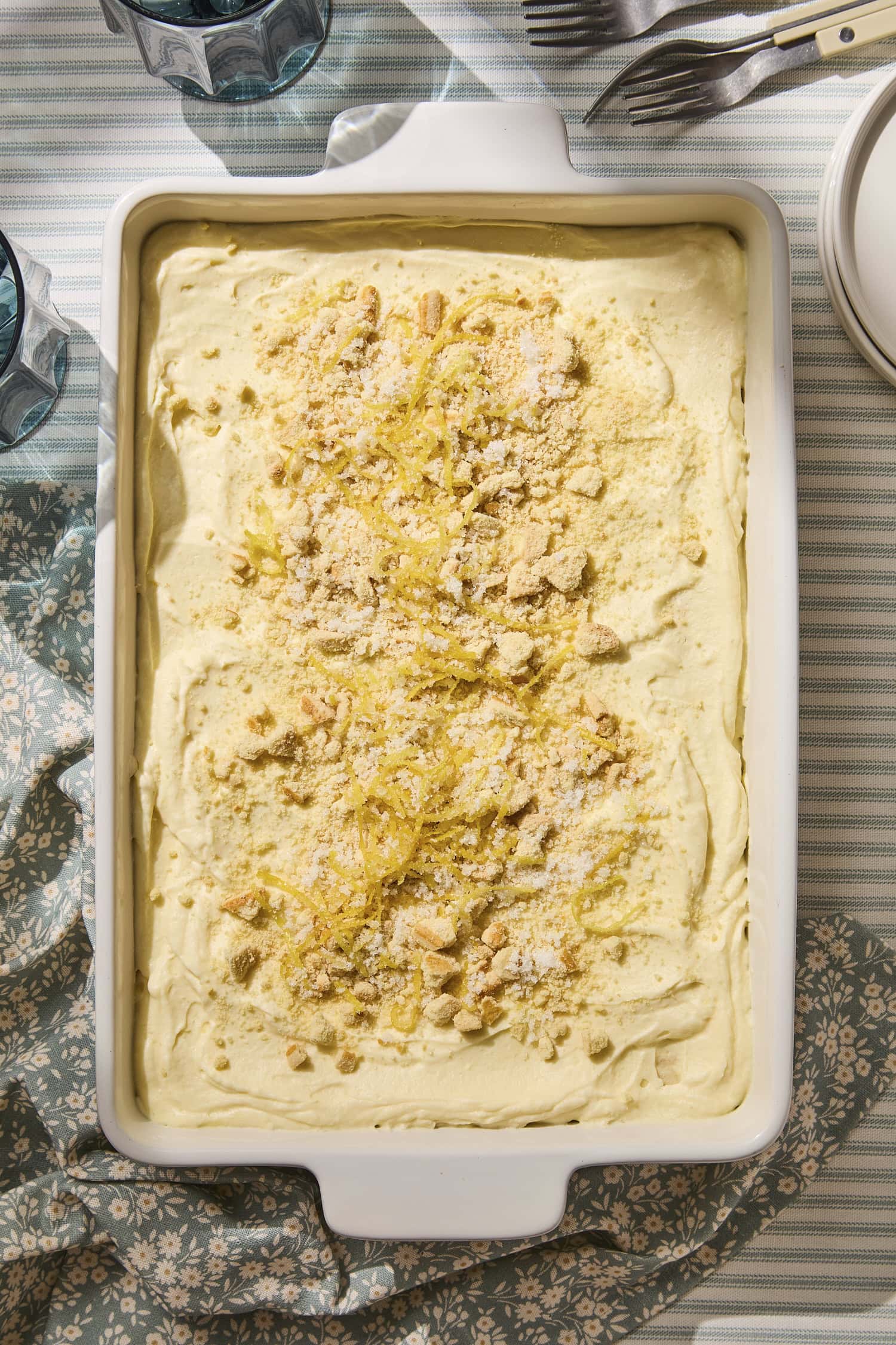 Lemon icebox cake with lemon zest and crumbled butter cookies on top.