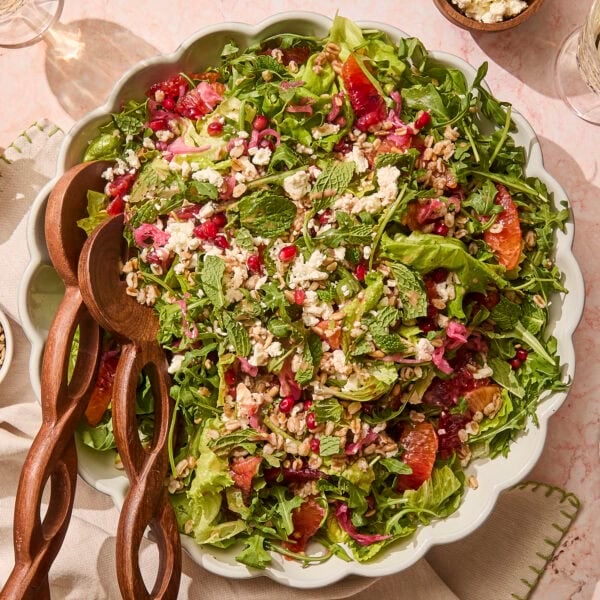Platter with greens and topped with farro, blood orange segments, pomegranates, feta, and more.