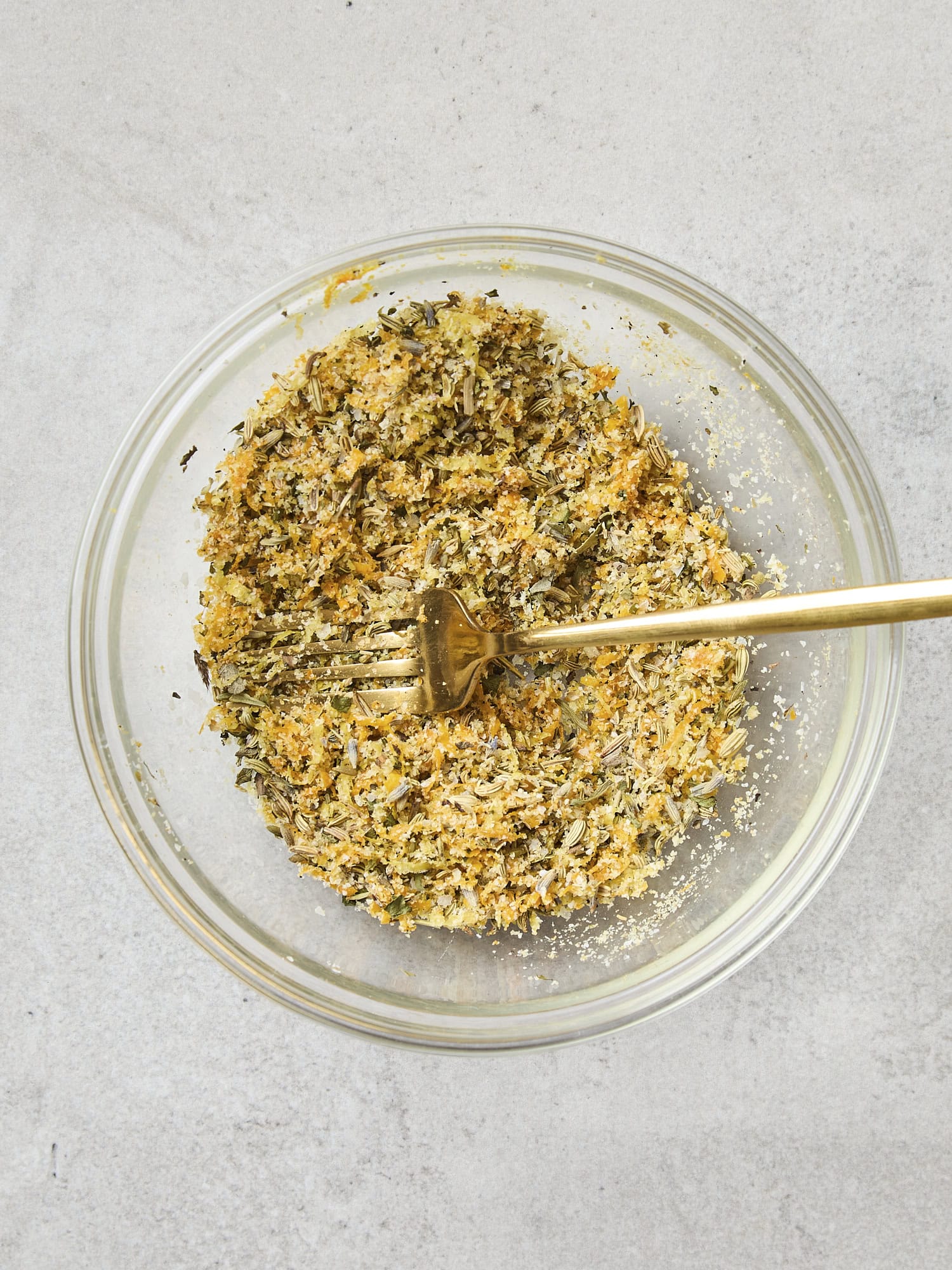Glass bowl with salt, citrus, and herb mixture.