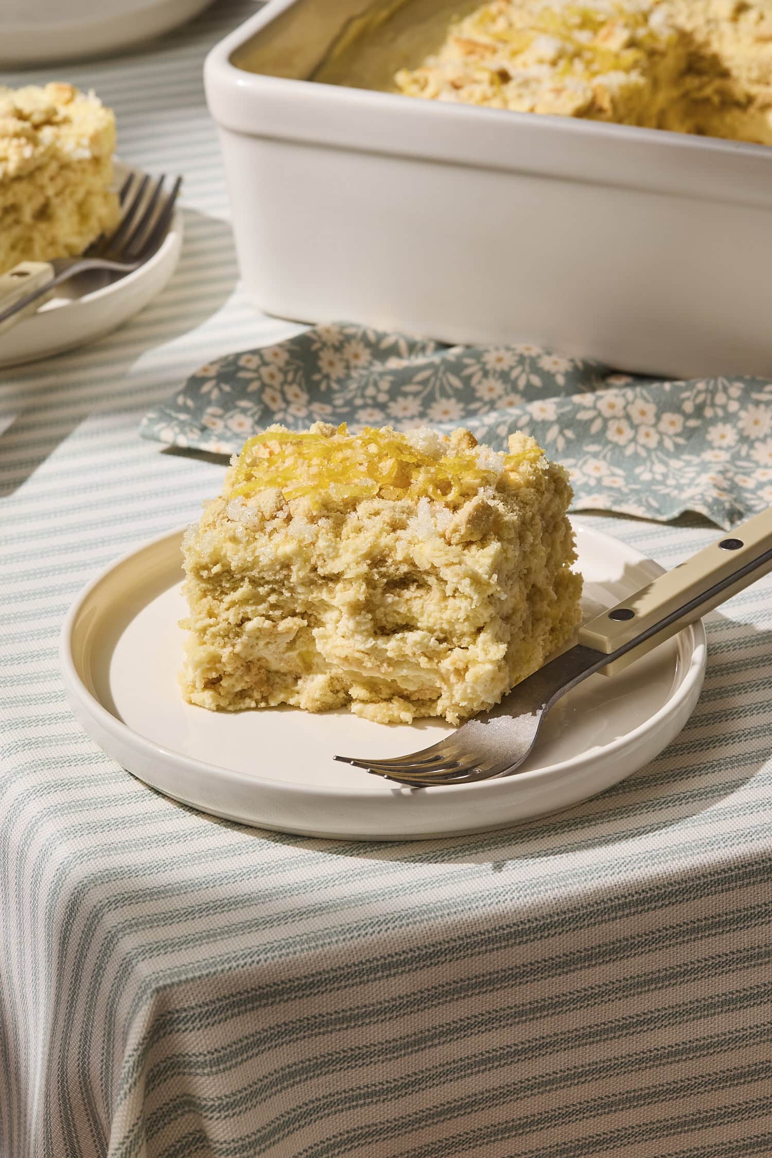 Plate with slice of lemon icebox cake with fork.