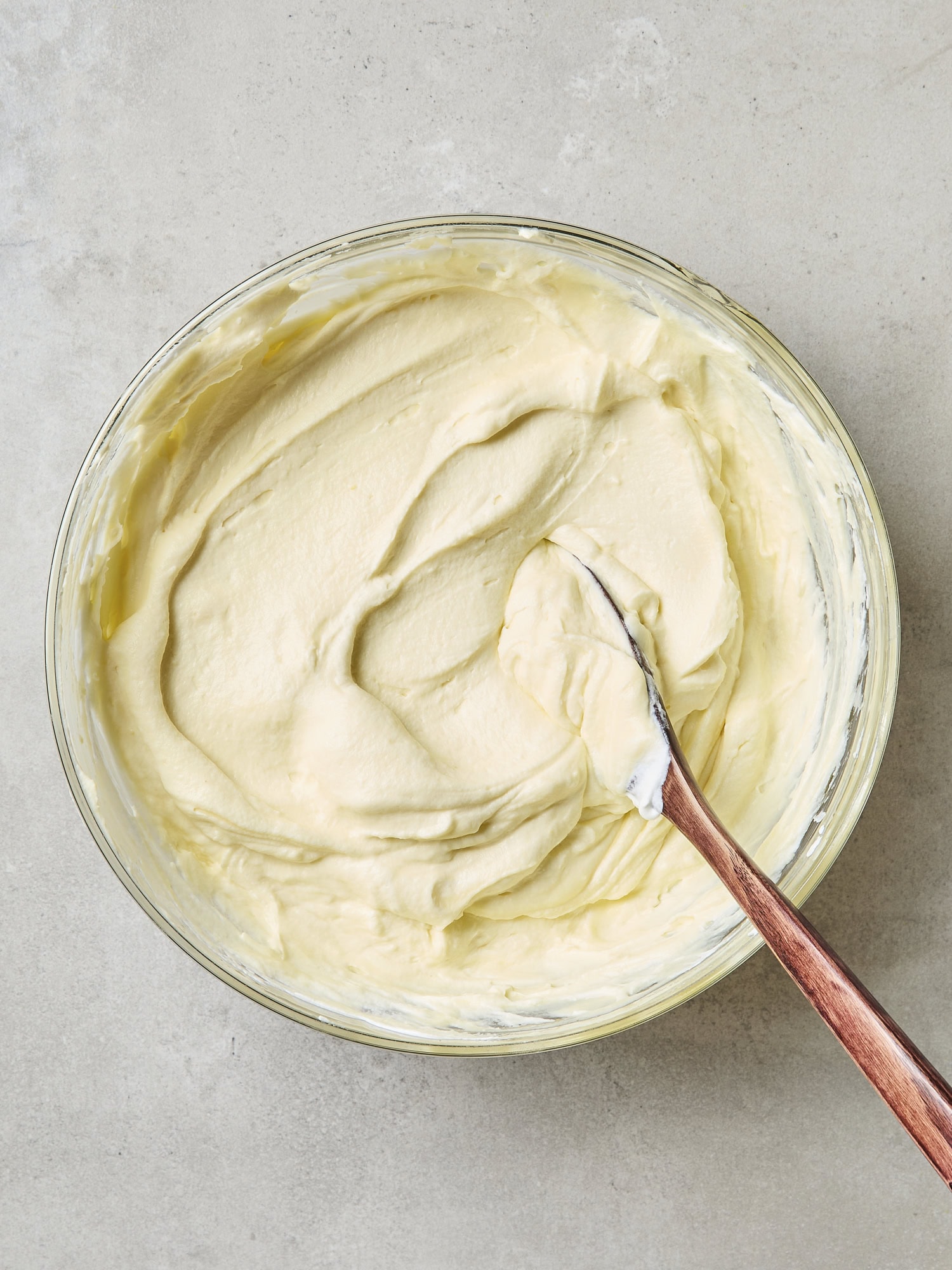 Glass bowl with mixture of whipped cream and lemon pudding.