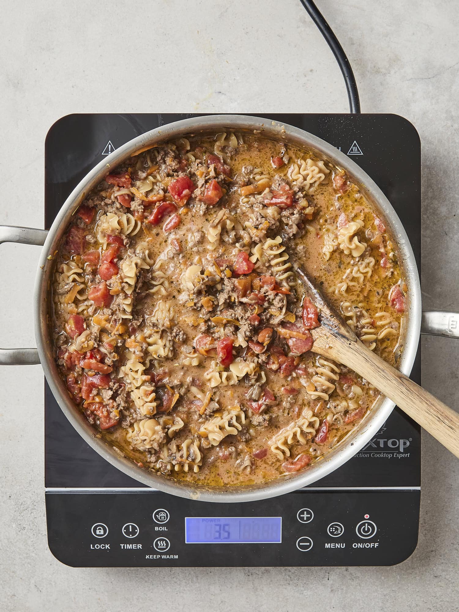 Pasta cooking in skillet for ragu.