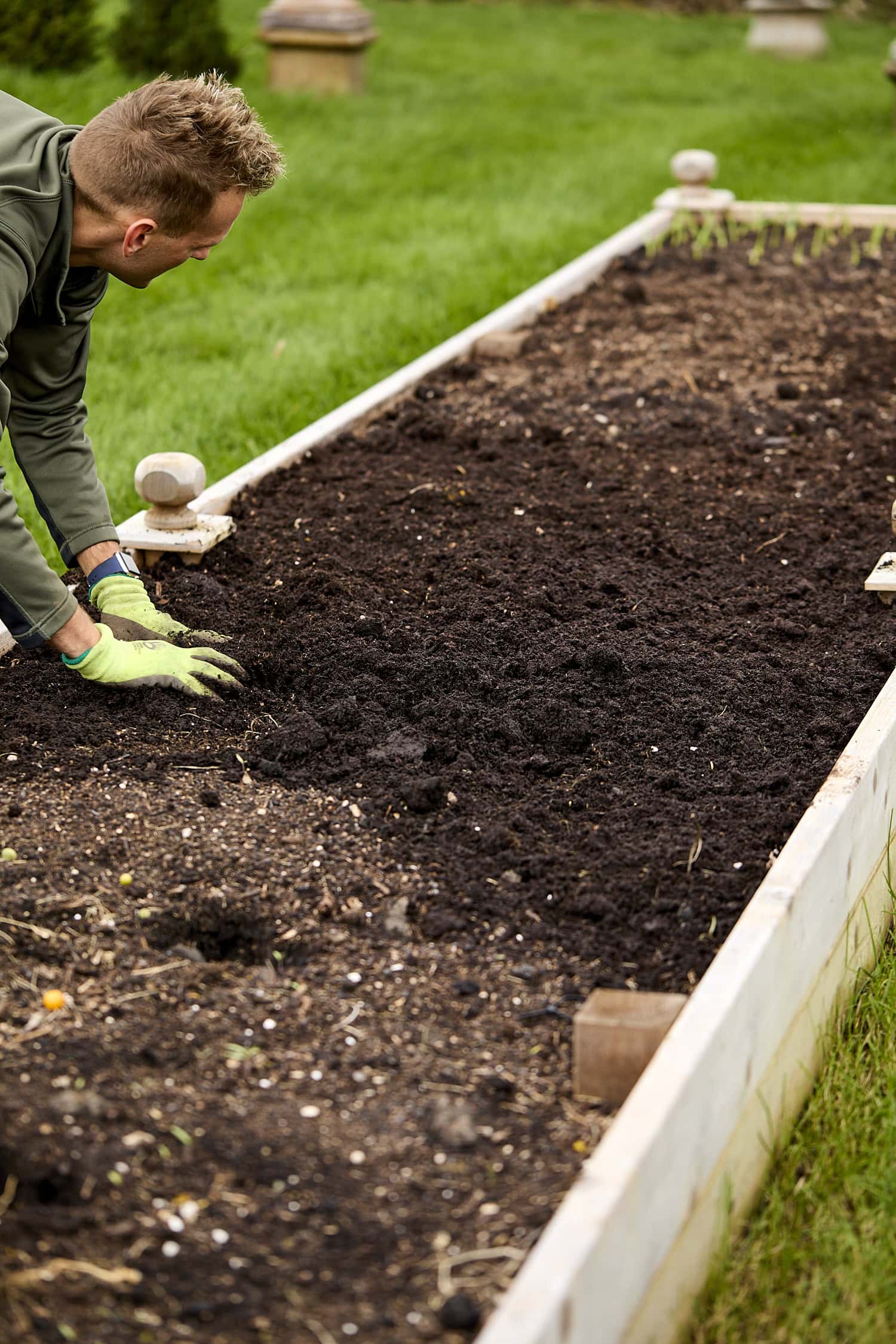 Kaleb adding compost to raised bed before planting garlic.