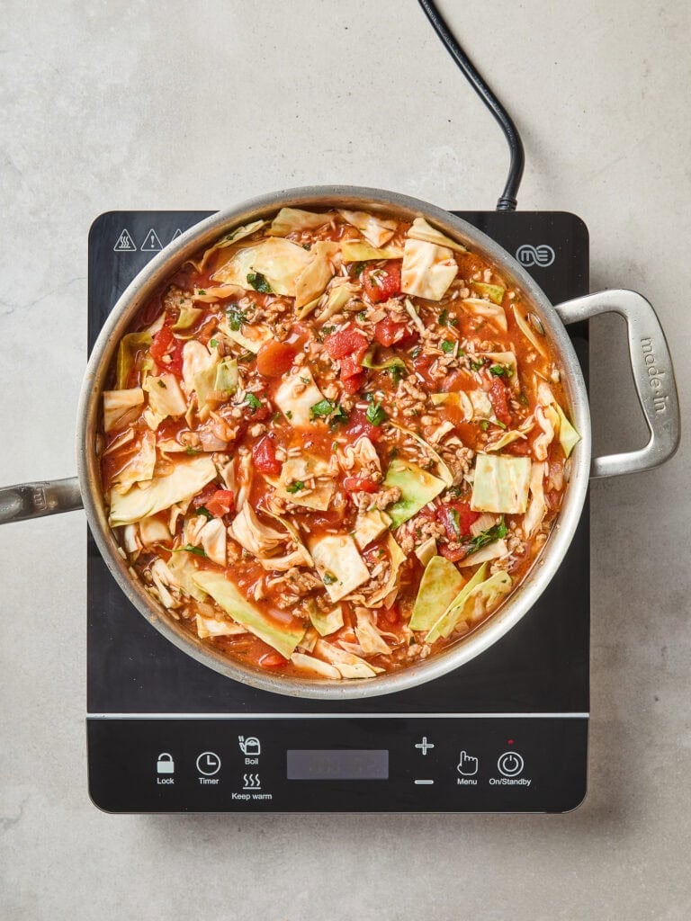 Tomato, cabbage, and rice cook down for a cabbage skillet.