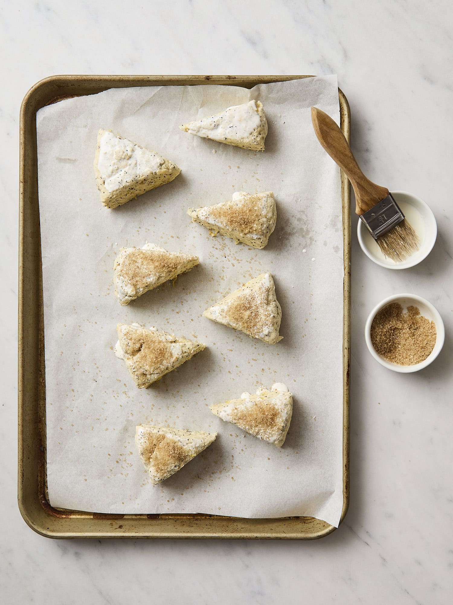 Scones with cream and turbinado sugar on top.