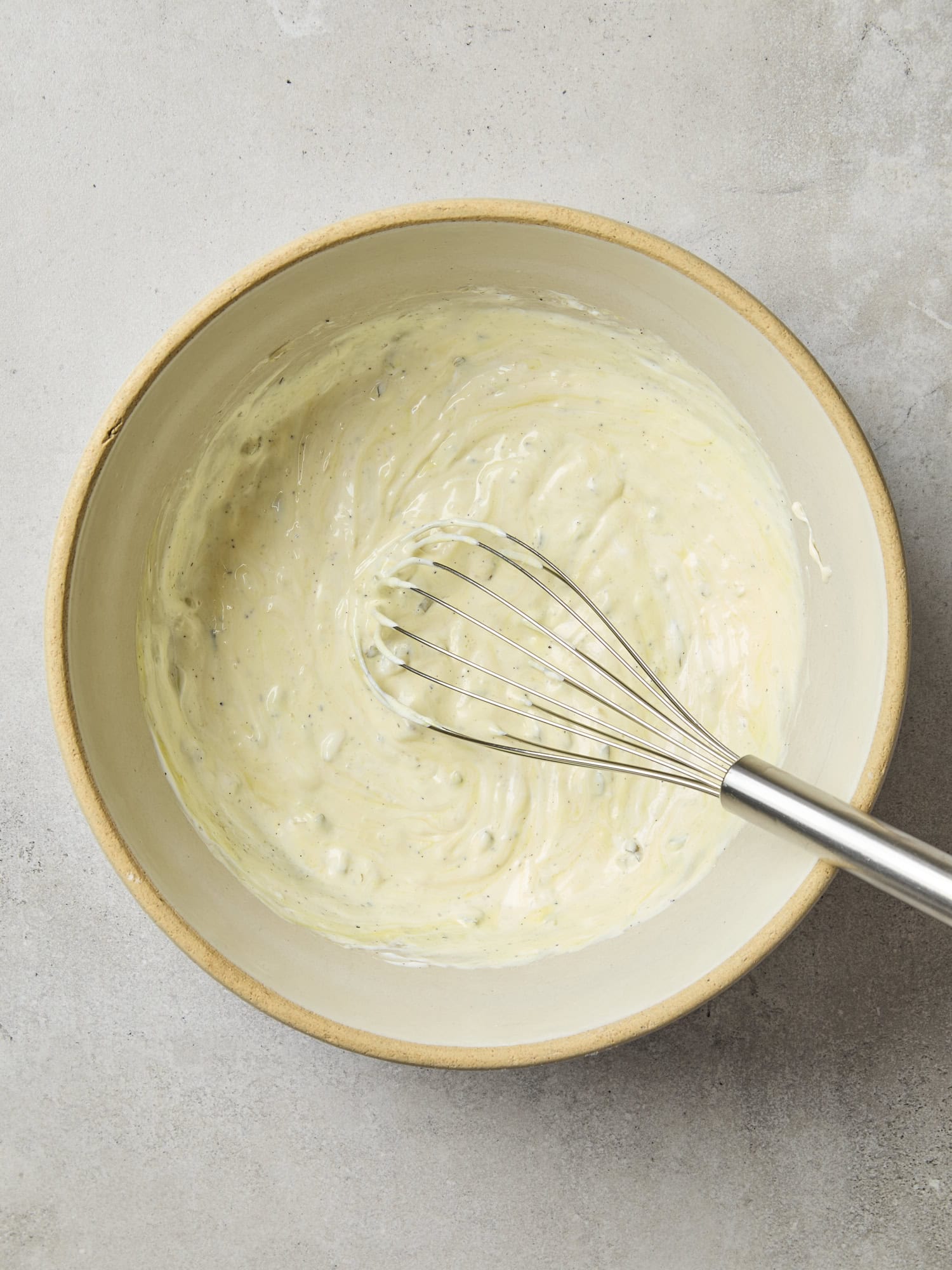 Bowl with creamy dressing for classic macaroni salad.