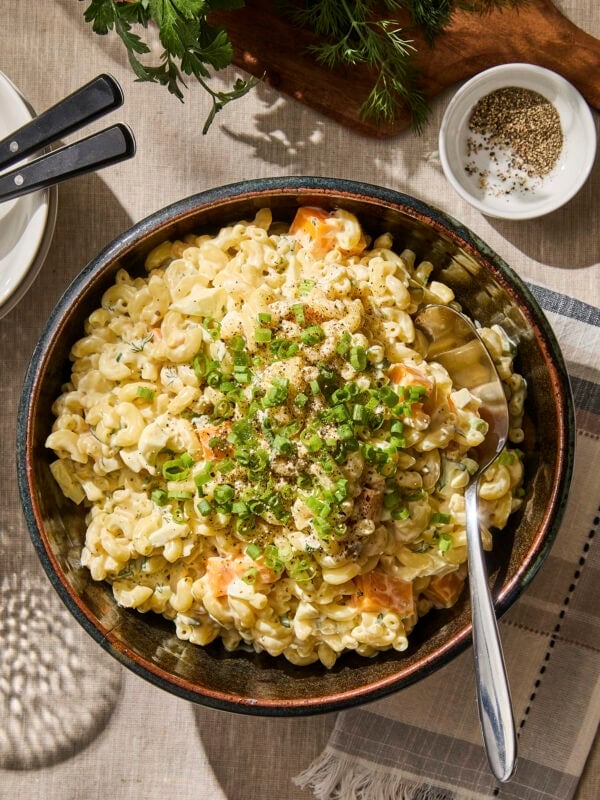 Macaroni salad in a large bowl with serving spoon.