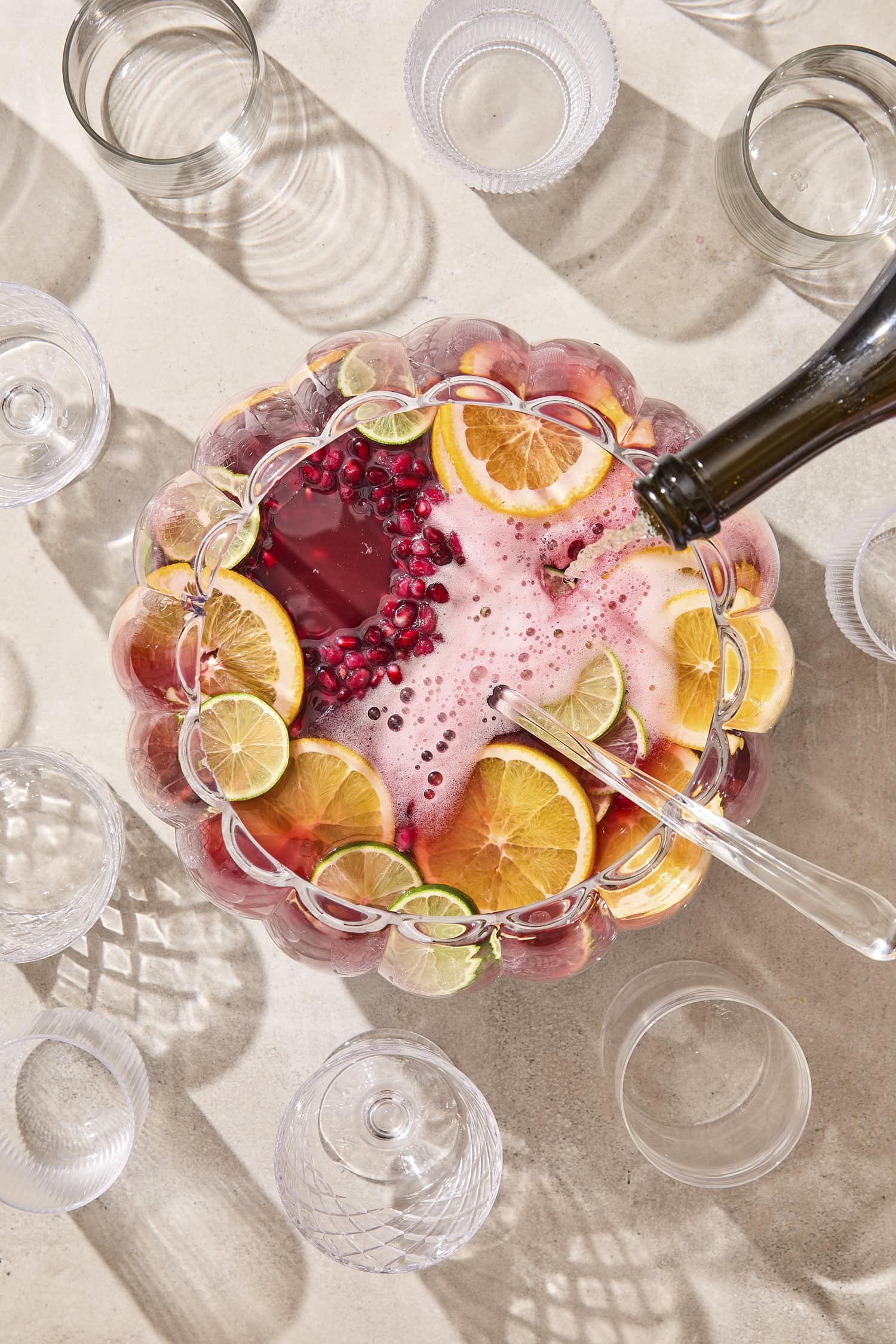 Champagne being poured on top of holiday punch with ice ring.