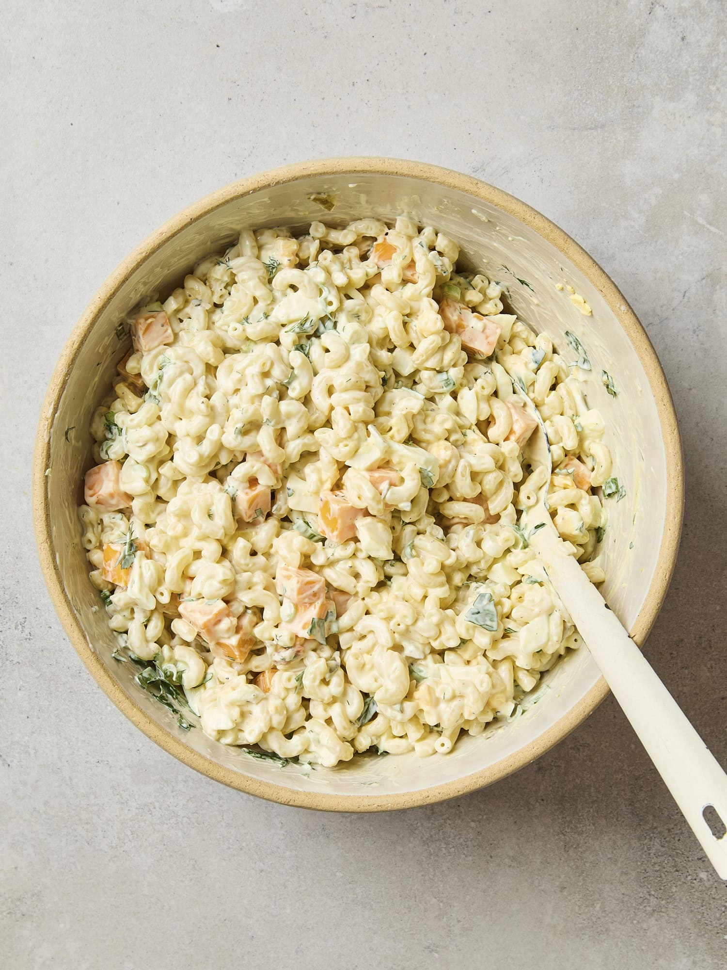 Macaroni salad with all ingredients mixed together.