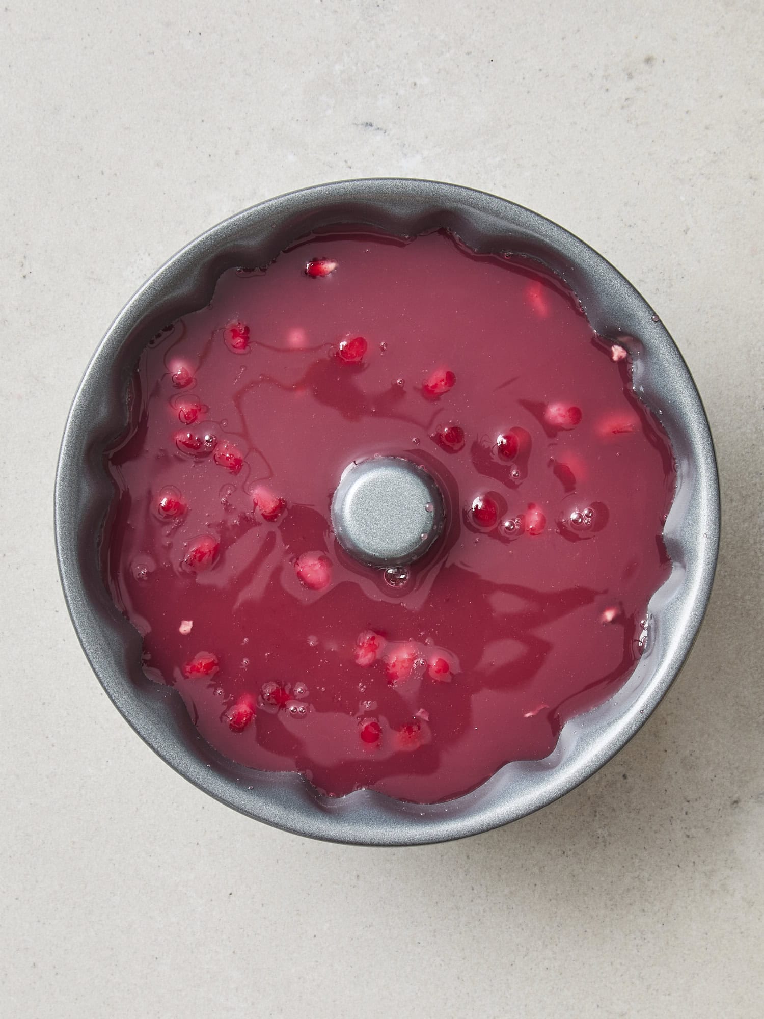 Pomegranate juice and arils in a pan to create an ice ring for punch.