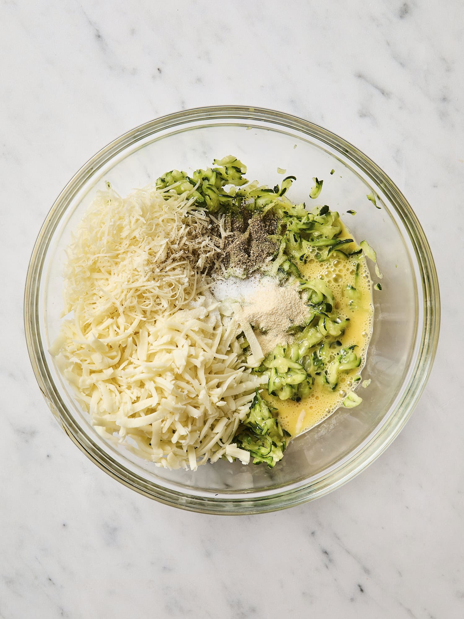 Mixture of zucchini, cheese, and spices for zucchini pizza casserole.