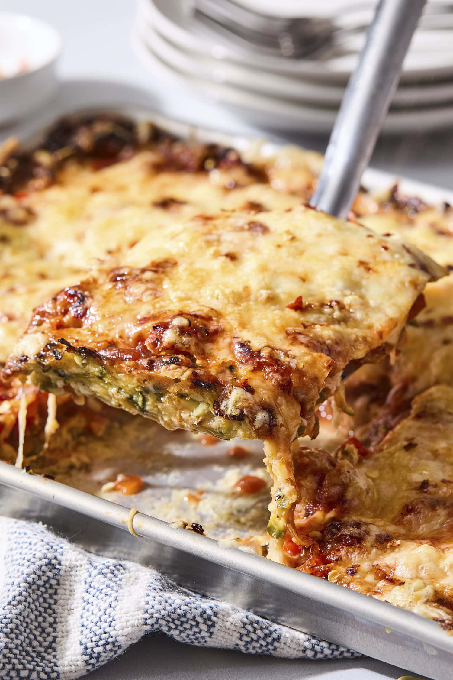 Serving of zucchini pizza being removed from pan.