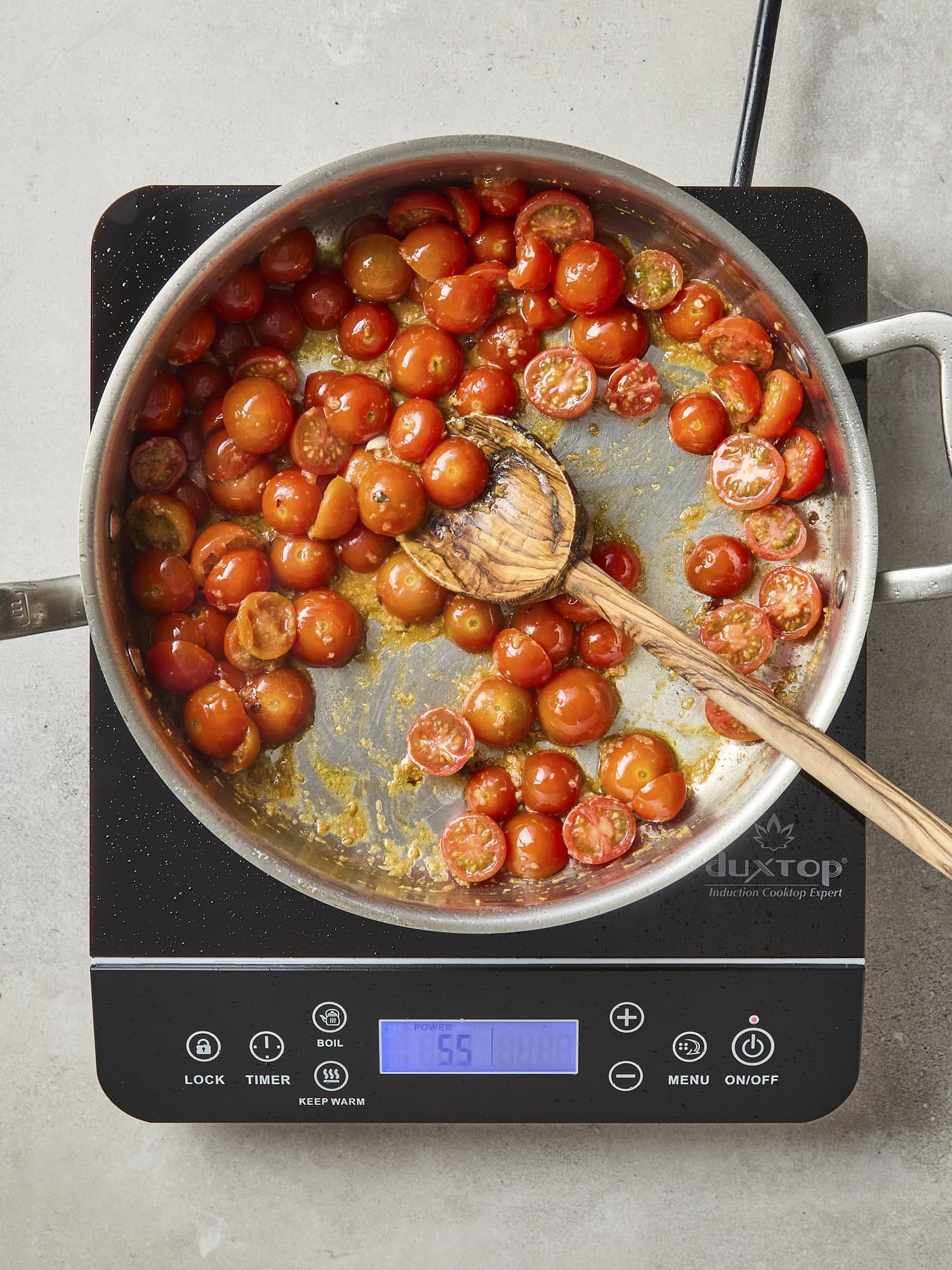 Burst cherry tomatoes in a pan.
