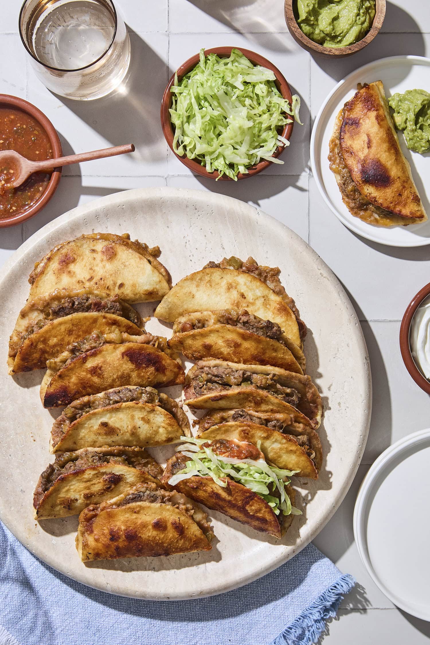 Assembled baked beef tacos with toppings.