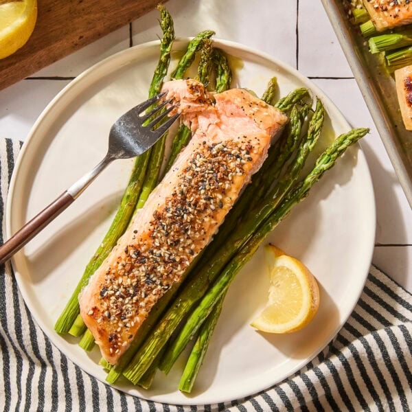 Salmon fillet with asparagus served on a plate.