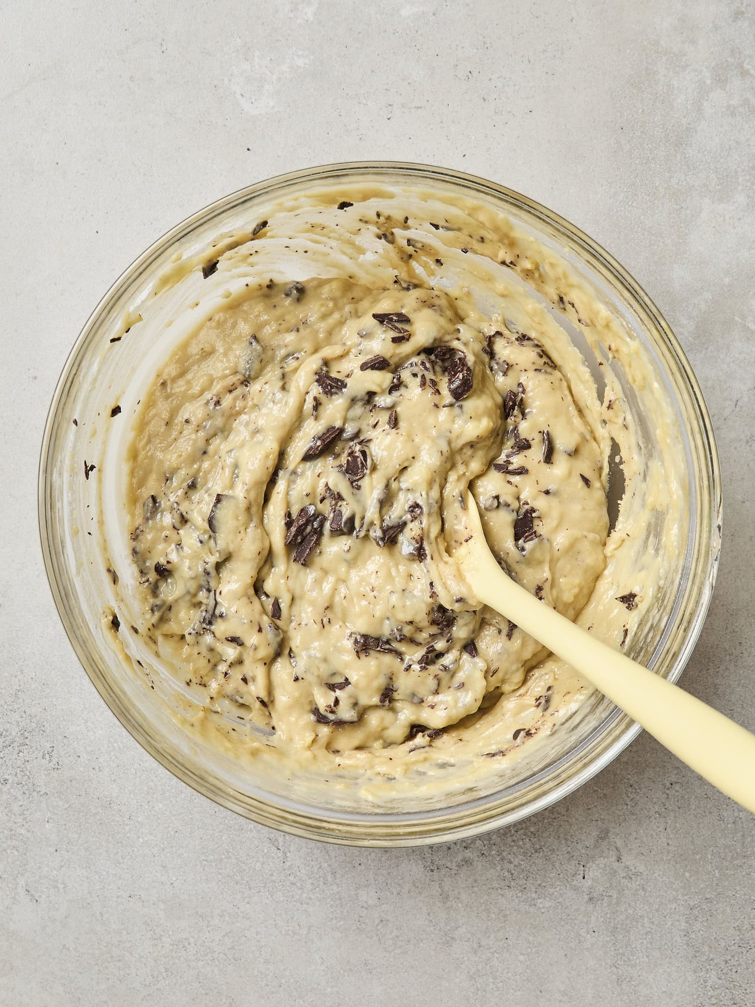 Pieces of chocolate mixed into batter for banana bread.