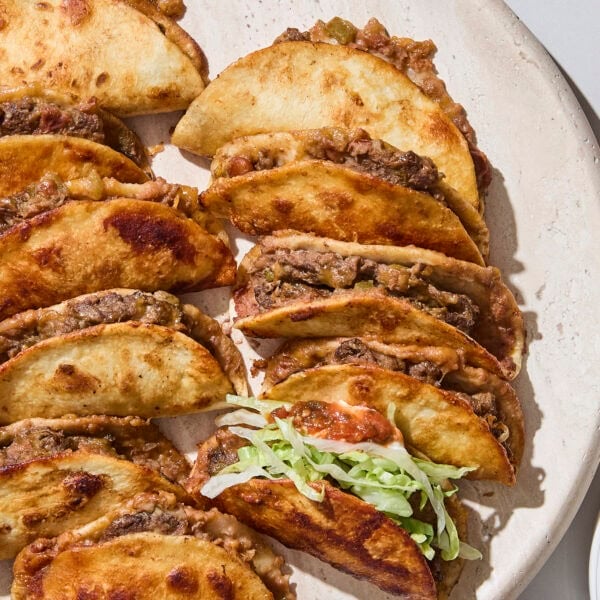 Platter filled with baked beef tacos.