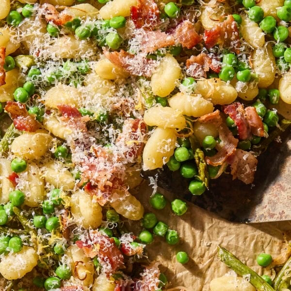 Mixture of gnocchi with bacon, asparagus, and peas on sheet pan.
