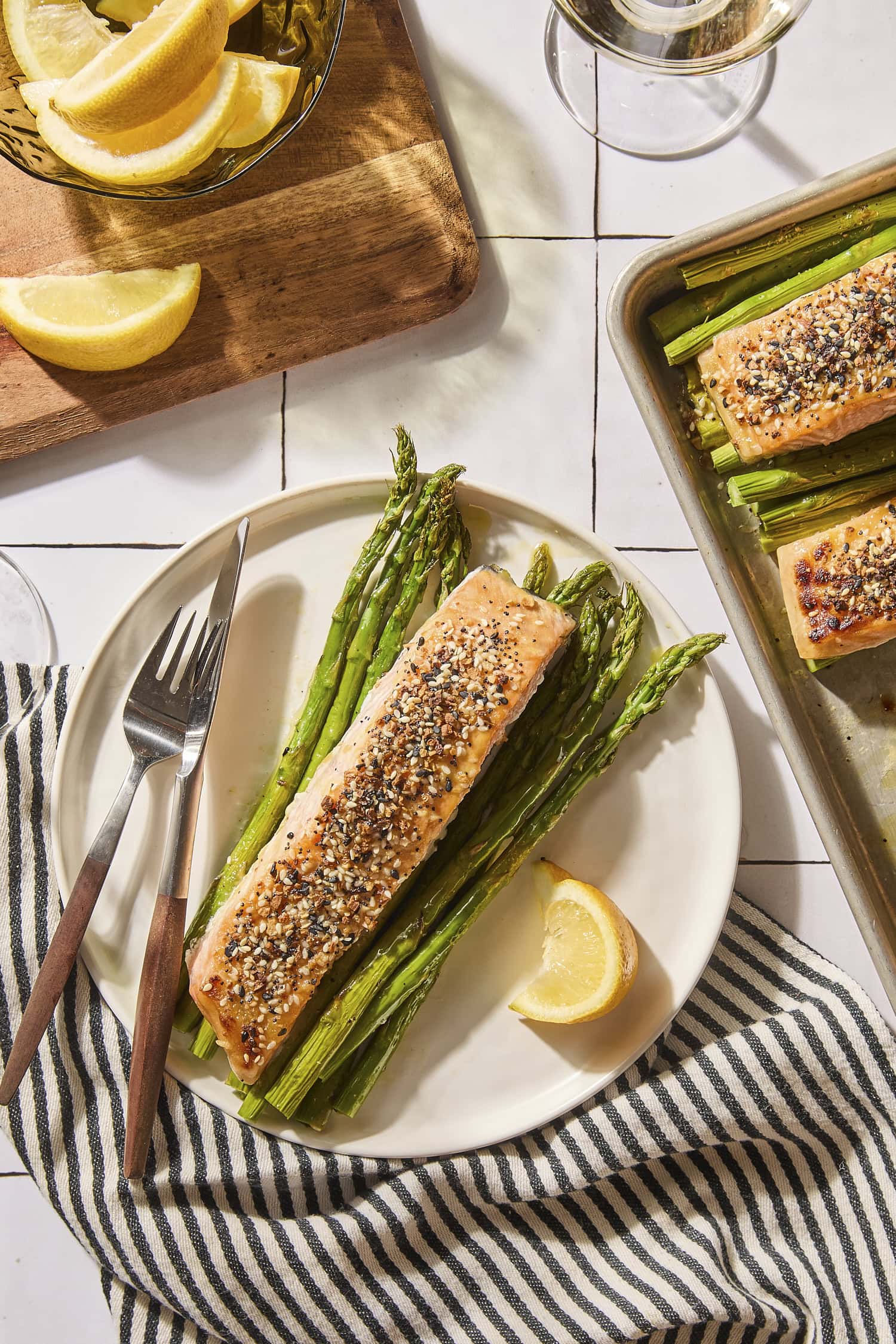 Sheet pan salmon and asparagus served on a plate with lemon to the side.